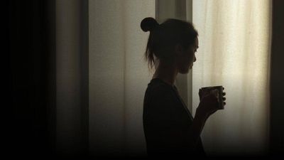 women by window with mug